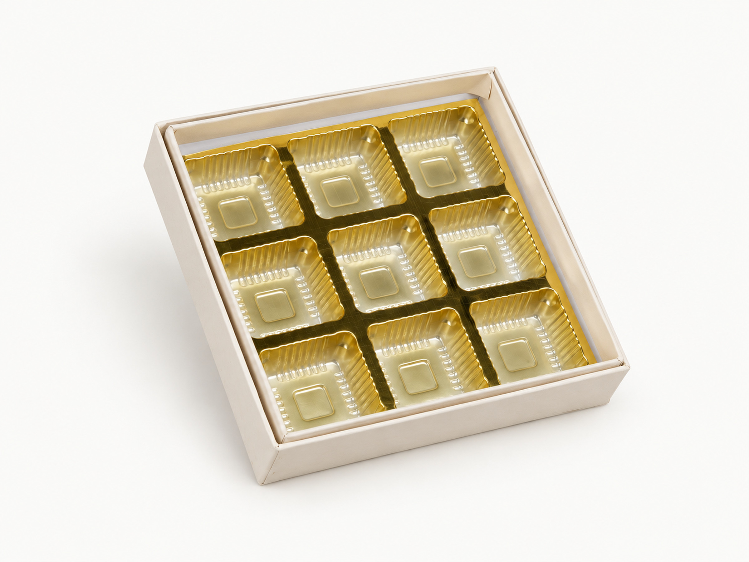 Open ivory chocolate box with a gold-coloured nine-cavity insert.